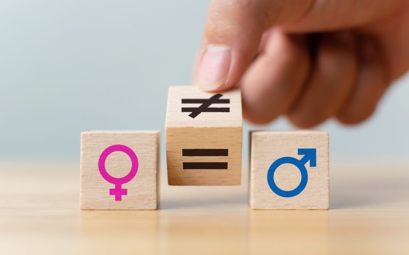 Concepts of gender equality. Hand flip wooden cube with symbol unequal change to equal sign Concepts of gender equality. Hand flip wooden cube with symbol unequal change to equal sign